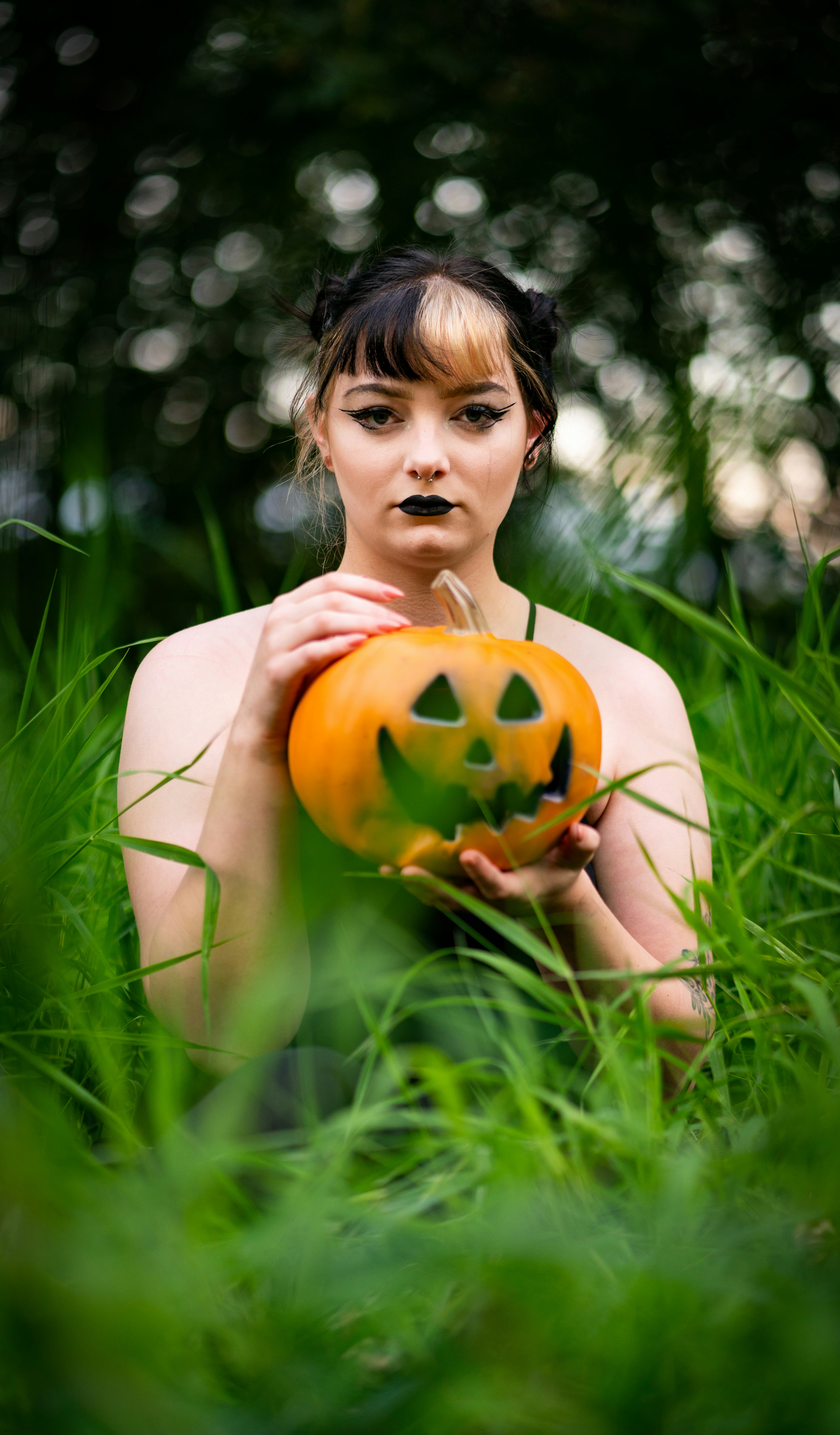 topless woman holding jack o lantern